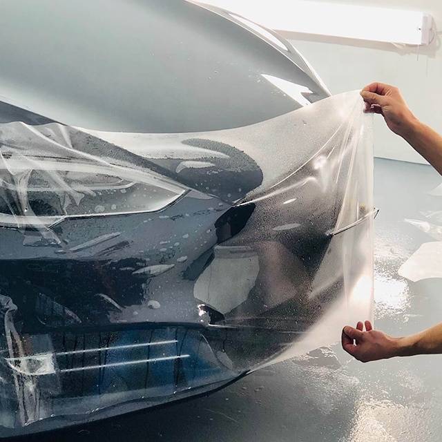 Une photo d'une voiture de sport noire bénéficiant d'une protection de carrosserie par film PPF, réalisée par une équipe de professionnels expérimentés chez GraphyLabs.